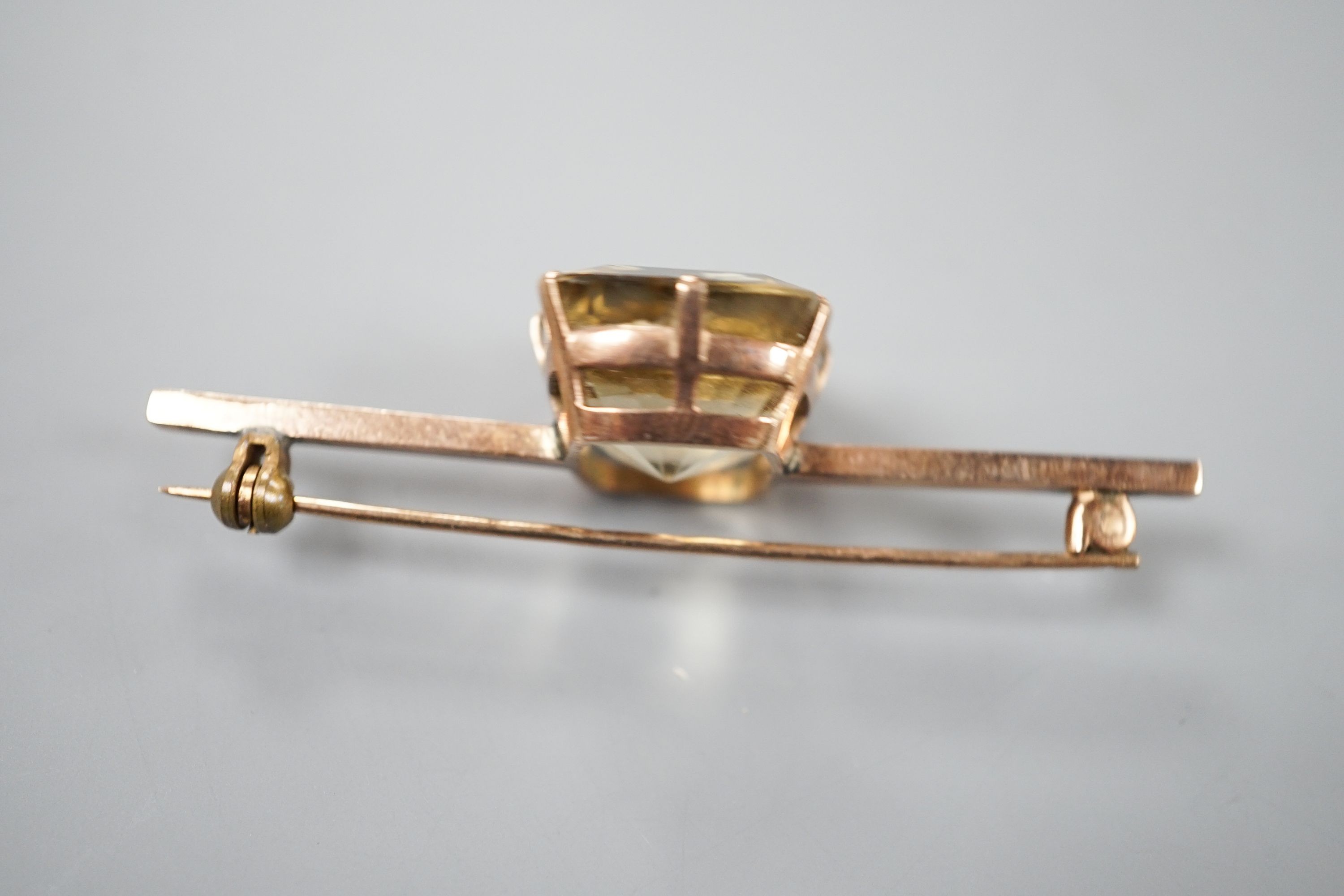 A yellow metal and citrine set bar brooch, 61mm, gross weight 11.9 grams.